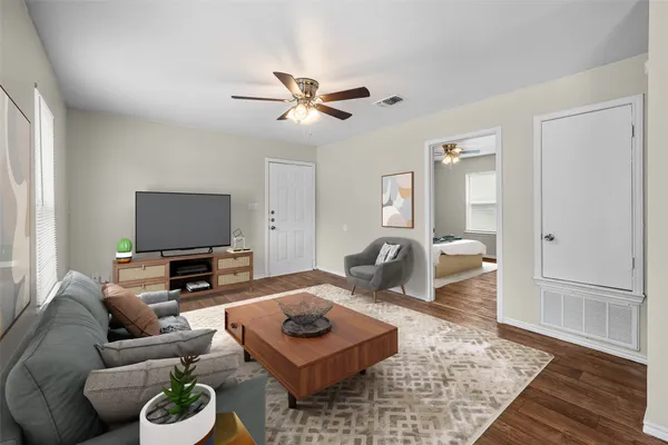 a living room with furniture a rug and a flat screen tv