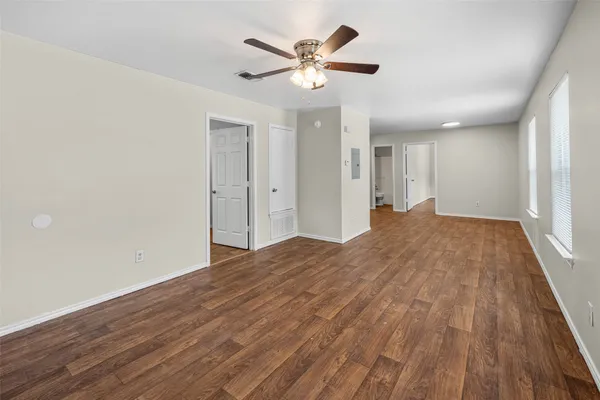 a view of empty room with wooden floor