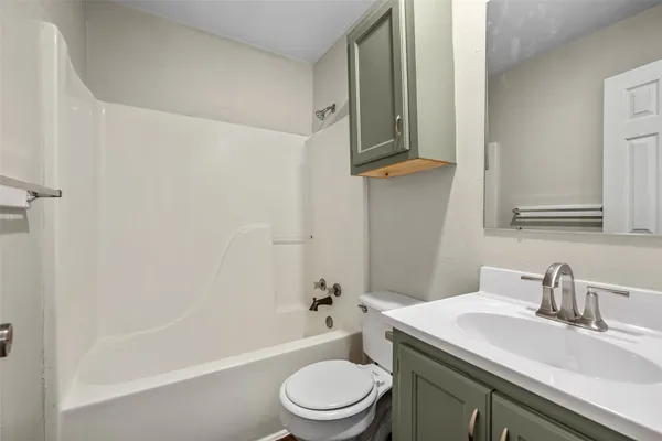 a bathroom with a granite countertop sink toilet a mirror and bathtub