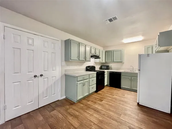 a kitchen with a refrigerator stove top oven and sink