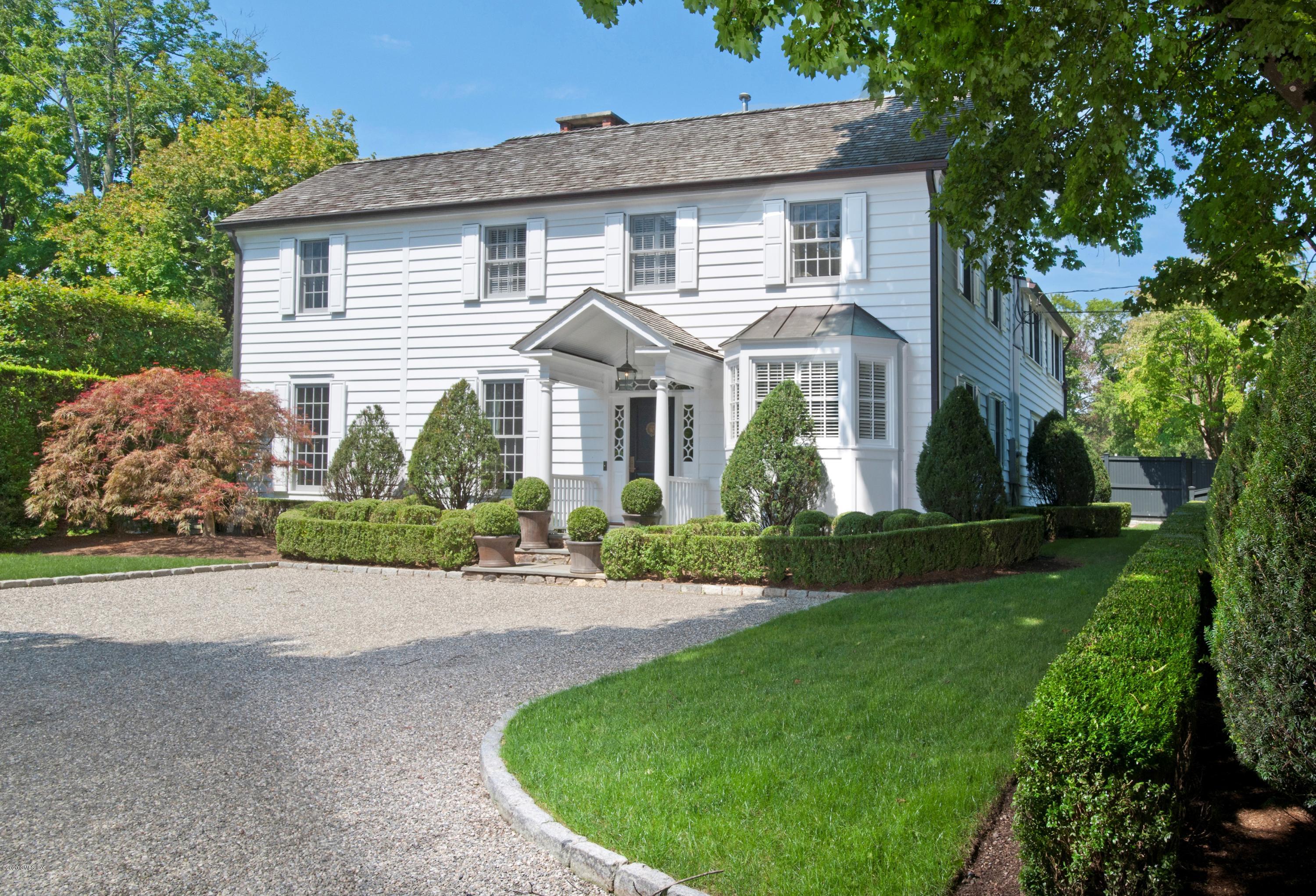 a front view of a house with a garden and plants
