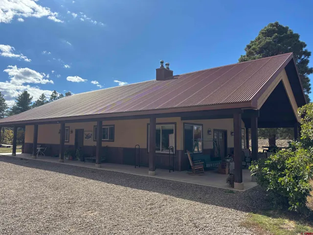 a front view of a house with a yard and potted plants