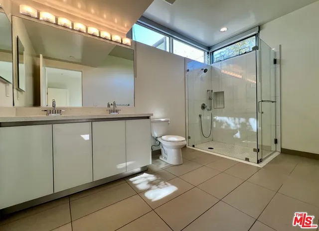 a bathroom with a double vanity sink mirror and toilet