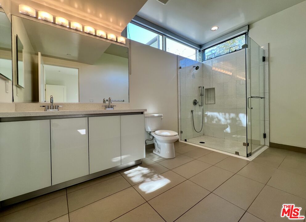 11715 Bellagio Road, Unit 104 Los Angeles, CA 90049 - Photo 11 of 26 a bathroom with a double vanity sink mirror and toilet