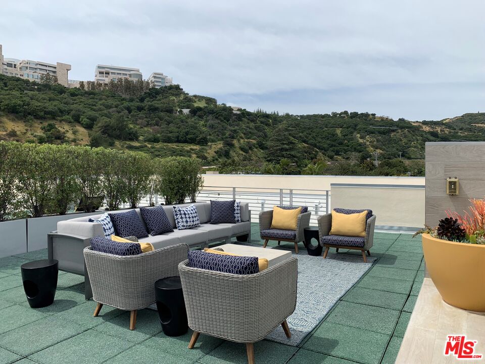 11715 Bellagio Road, Unit 104 Los Angeles, CA 90049 - Photo 20 of 25 a view of a patio with couches chairs and a potted plant