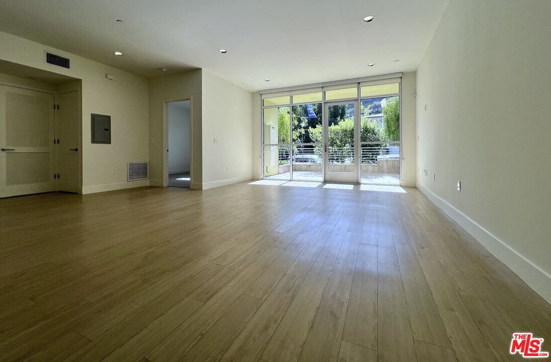 11715 Bellagio Road, Unit 104 Los Angeles, CA 90049 - Photo 4 of 26 a view of room with furniture and wooden floor