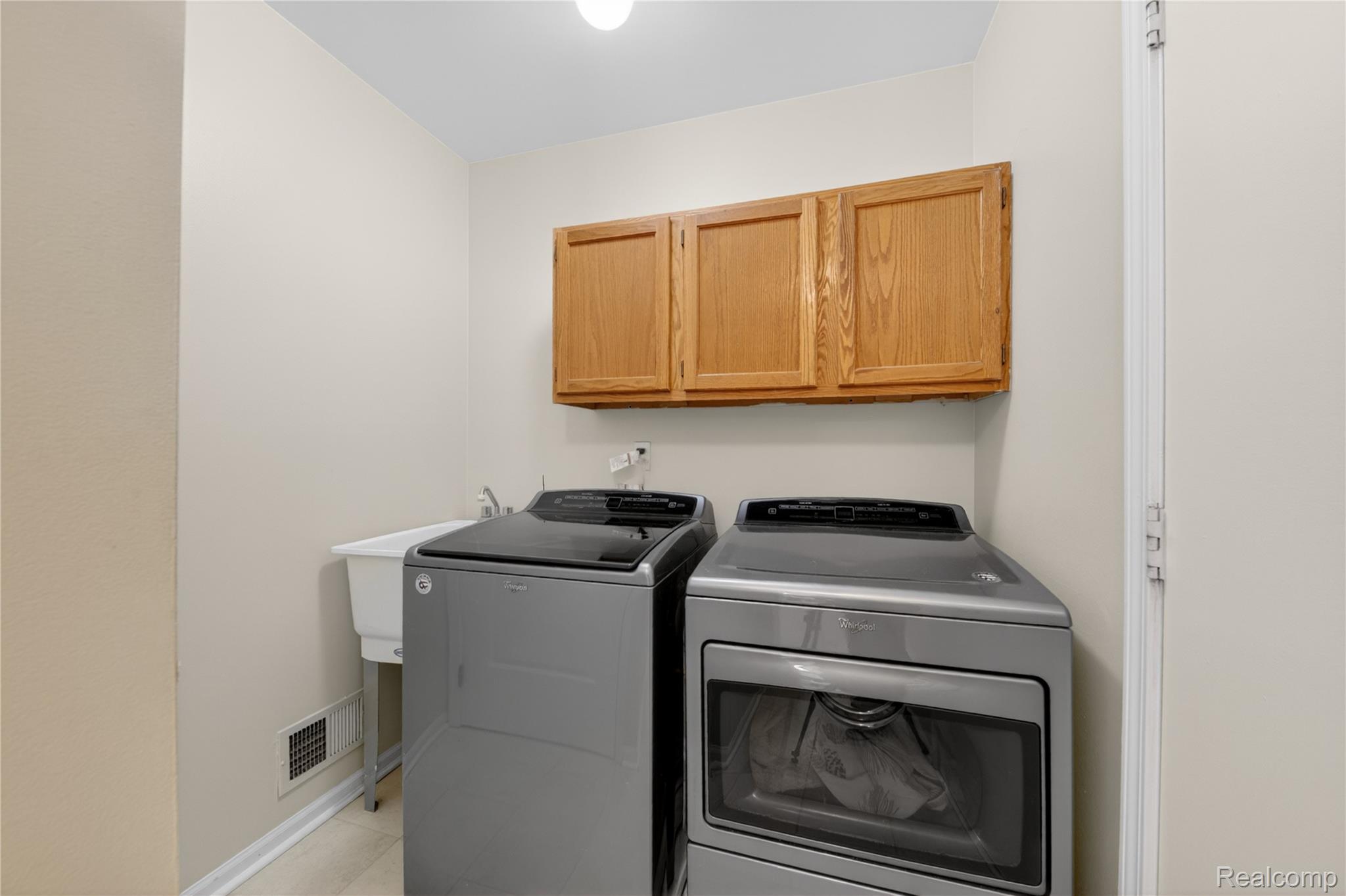 44570 Ridgefield Road Canton, MI 48188 - Photo 17 of 31 Dedicated laundry area featuring overhead wood cabinetry, a utility sink, and light-toned walls