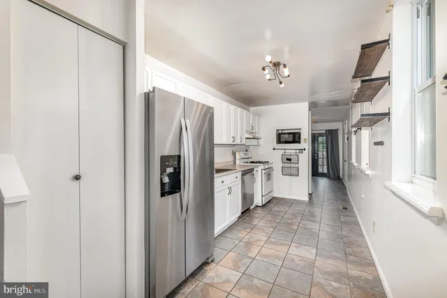 a kitchen with stainless steel appliances a refrigerator sink and cabinets