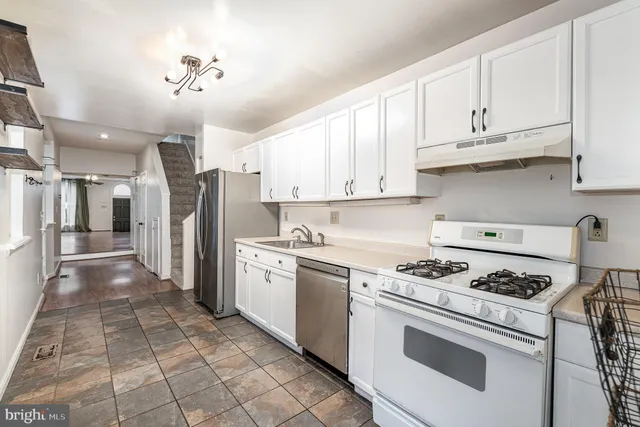a kitchen with stainless steel appliances granite countertop a stove a refrigerator and cabinets