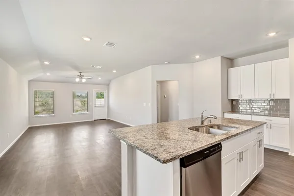 a kitchen with a sink cabinets and wooden floor