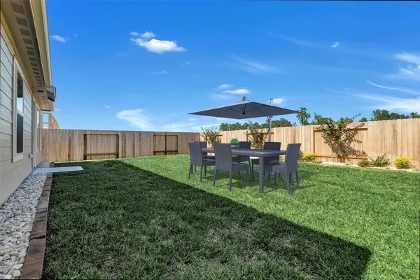 a view of a house with backyard and sitting area