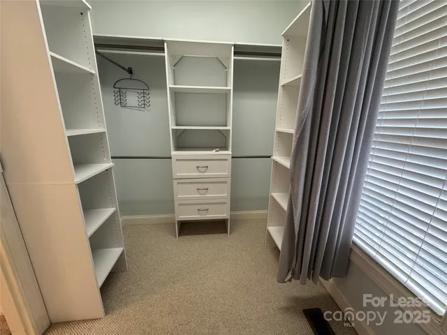 a view of walk in closet with empty racks