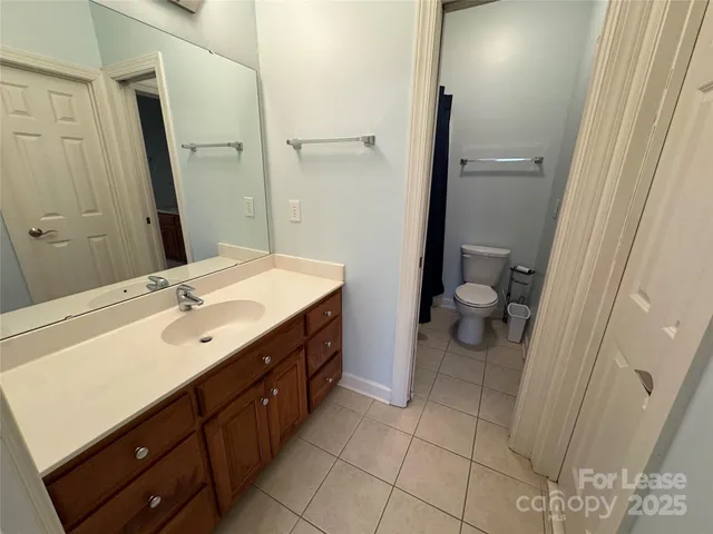 an empty room with a chandelier fan and windows