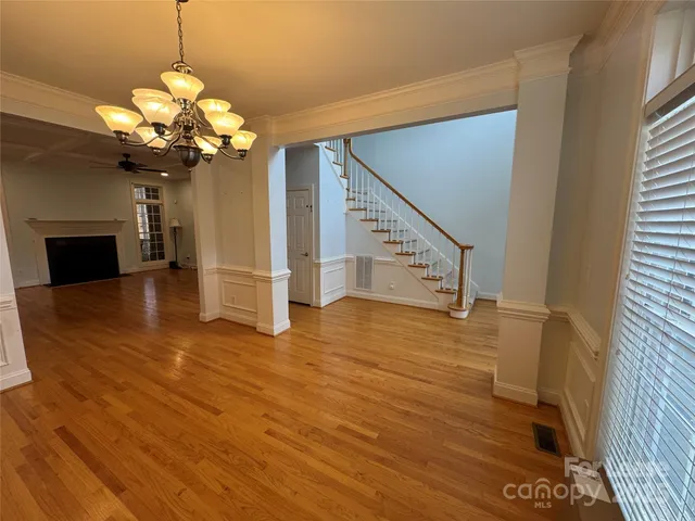 a view of a room with wooden floor fan and windows