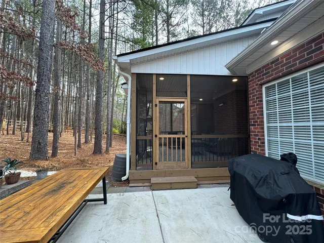 a backyard of a house with barbeque oven table and chairs