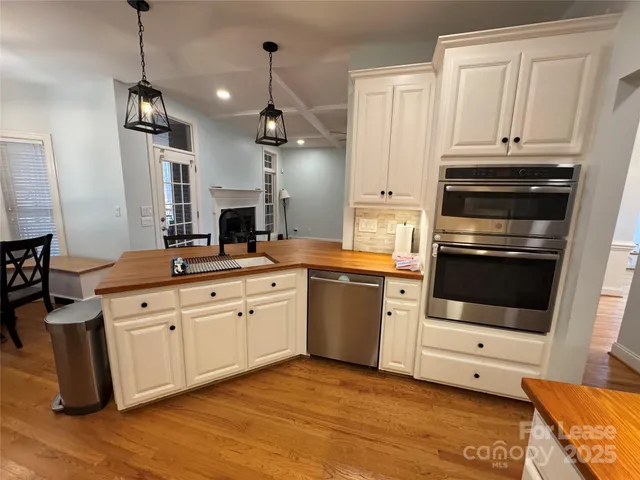 a kitchen with stainless steel appliances granite countertop a stove and white cabinets