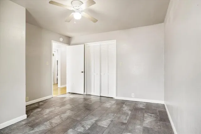a view of an empty room and chandelier fan