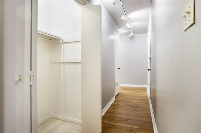 a view of a hallway with wooden floor