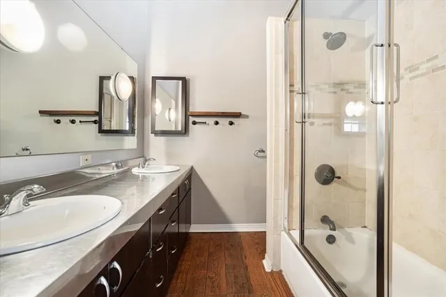 a bathroom with a granite countertop shower sink vanity and mirror