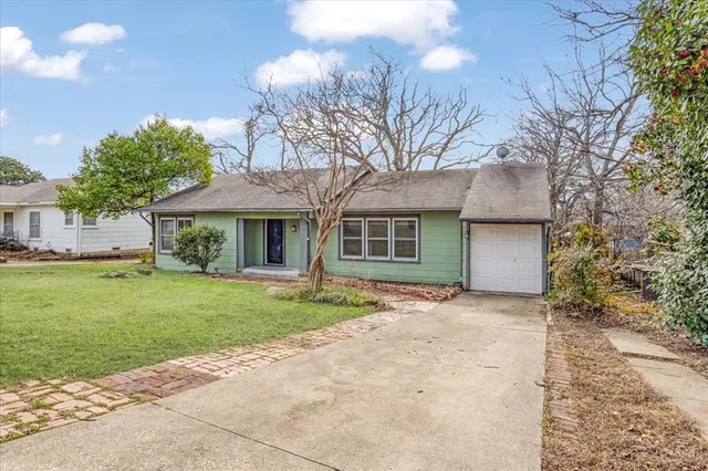 a front view of a house with a garden and yard