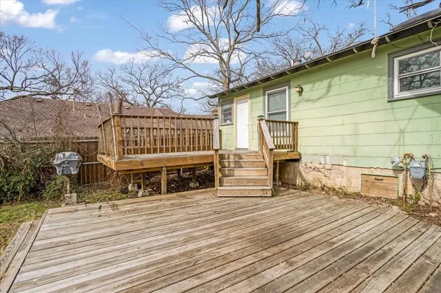 a view of a patio with table and chairs with wooden floor and fence