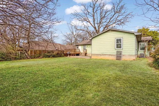 a view of a backyard with plants and large trees