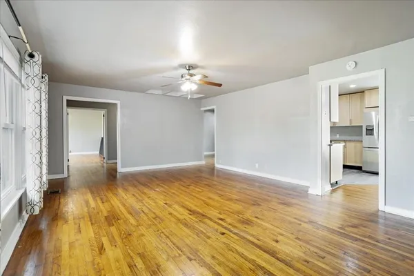 a view of a livingroom with wooden floor and a bedroom
