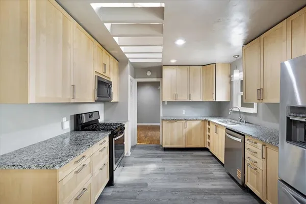 a kitchen with granite countertop white cabinets and white appliances