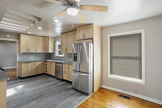 a kitchen with stainless steel appliances granite countertop a refrigerator a sink and a stove