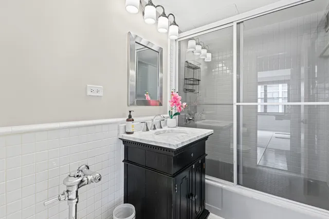 a bathroom with a granite countertop sink a toilet and shower