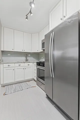 a kitchen with cabinets stainless steel appliances and a window