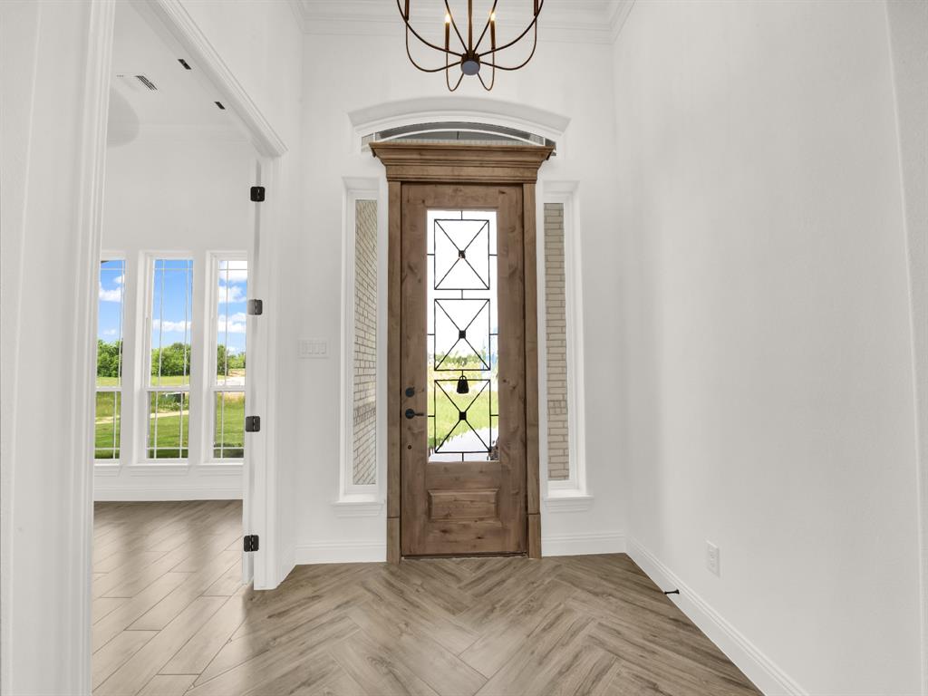 143 Desperado Way Weatherford, TX 76088 - Photo 7 of 36 Entrance foyer featuring a chandelier, baseboards, and ornamental molding