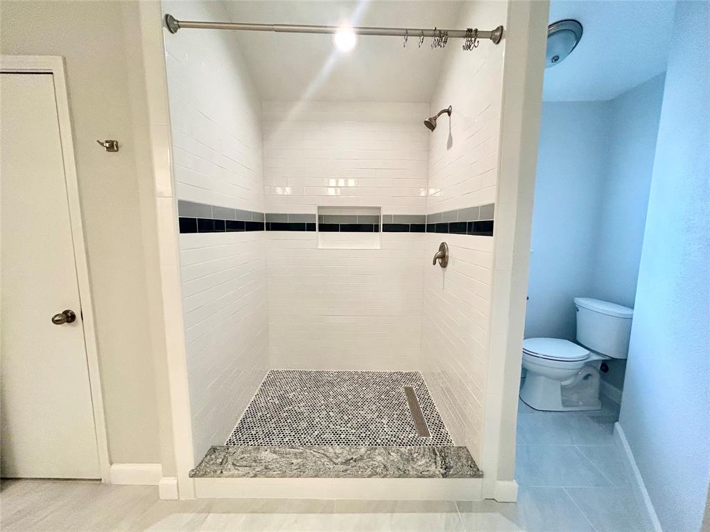 415 Rifleman Trail Arlington, TX 76002 - Photo 17 of 22 This primary bathroom shower is all new and it is gorgeous! This bathroom has two different closets.