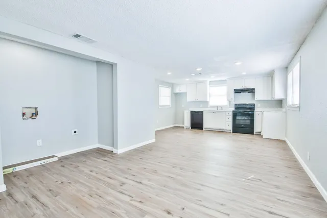 a view of a kitchen with a sink and wooden cabinets