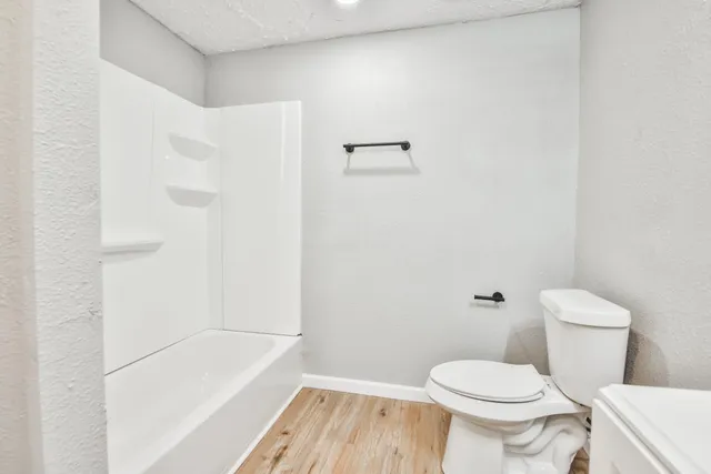 a white toilet sitting next to a bath tub