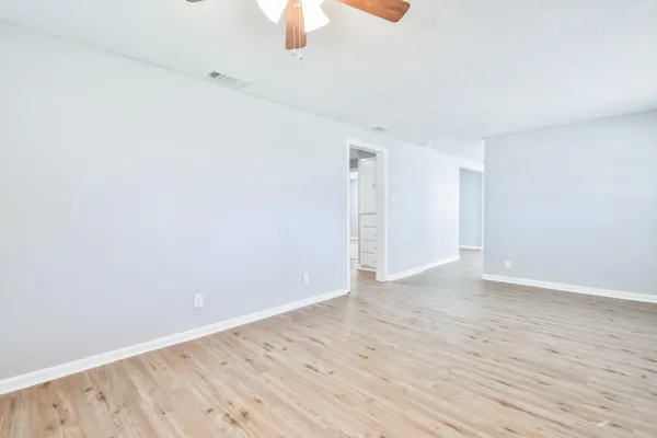 a view of an empty room with wooden floor