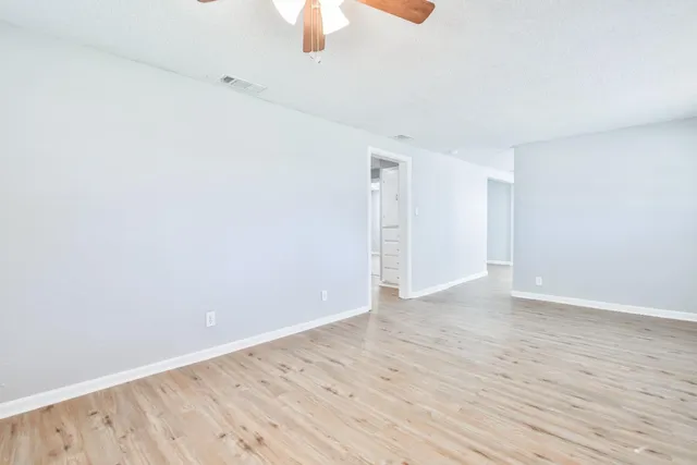 a view of an empty room with wooden floor