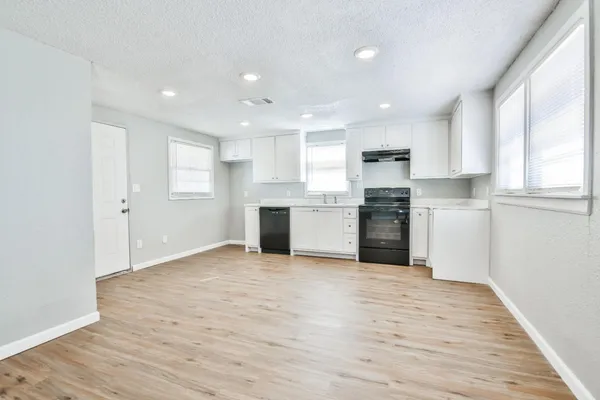 a view of a kitchen with a sink a refrigerator and window