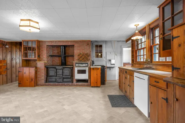 a view of a kitchen with stainless steel appliances granite countertop a stove and a window