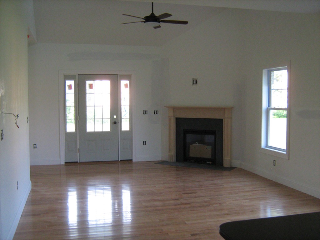 302 Piper Road, Unit 2A West Springfield, MA 01089 - Photo 4 of 6 an empty room with wooden floor fireplace and windows