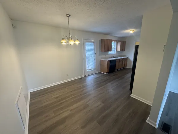 a kitchen with sink a refrigerator and wooden floor