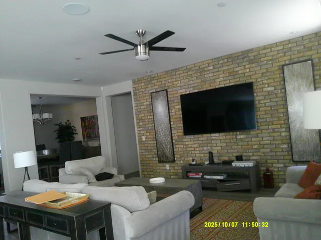 a living room with furniture wooden floor and a flat screen tv