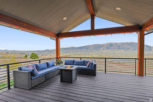 4527 North Seven Bridges Road Eden, UT 84310 - Photo 45 of 65 Deck with a mountain view and an outdoor living space with a fire pit