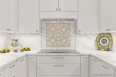 a kitchen with white cabinets and appliances