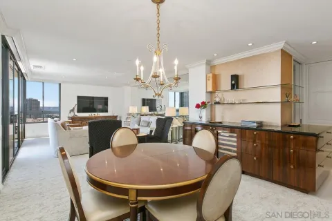 a dining room with furniture a chandelier and kitchen view