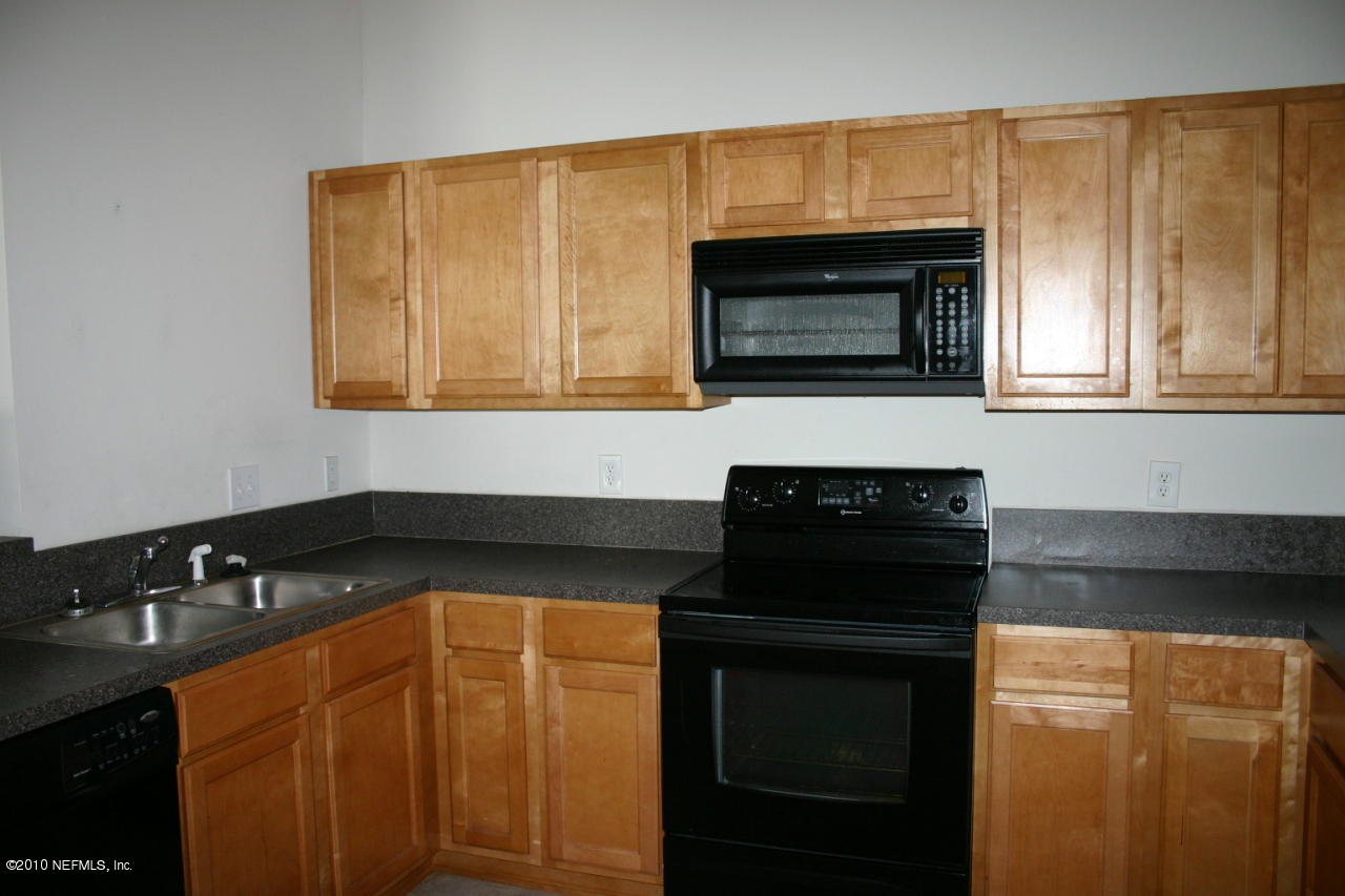 a kitchen with granite countertop white cabinets and black appliances