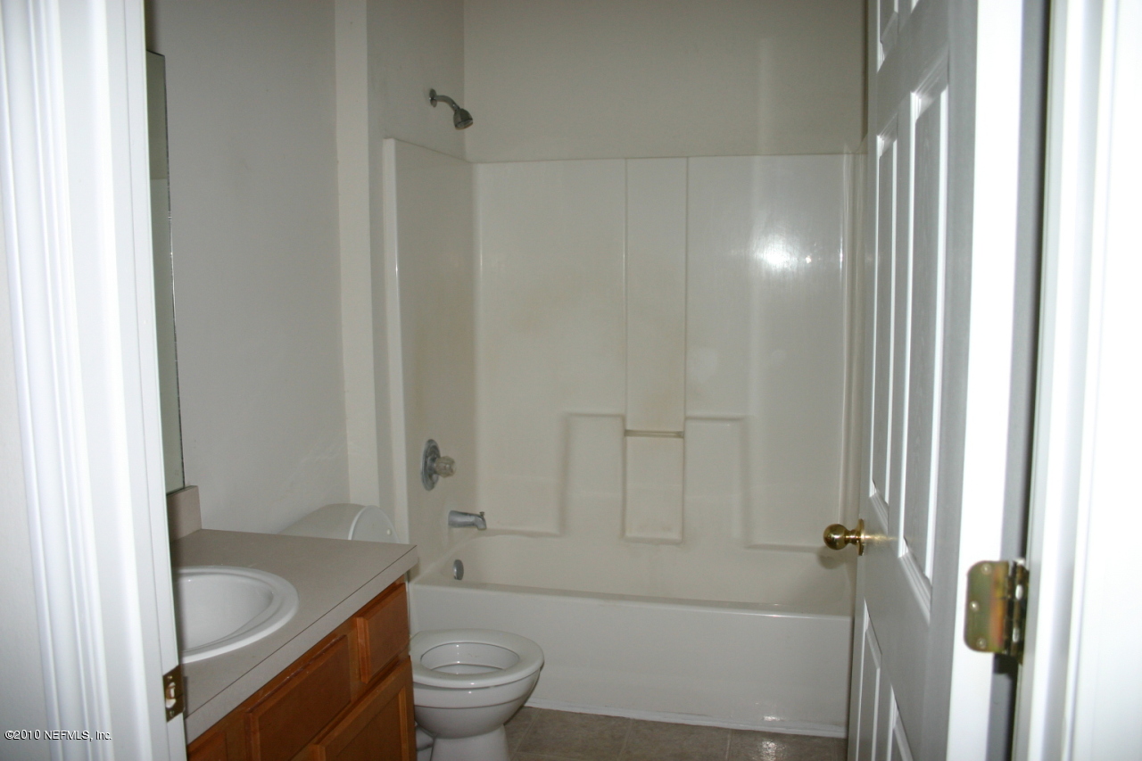 7920 Merrill Road, Unit 1002 Jacksonville, FL 32277 - Photo 9 of 18 a bathroom with a granite countertop bathtub shower and toilet