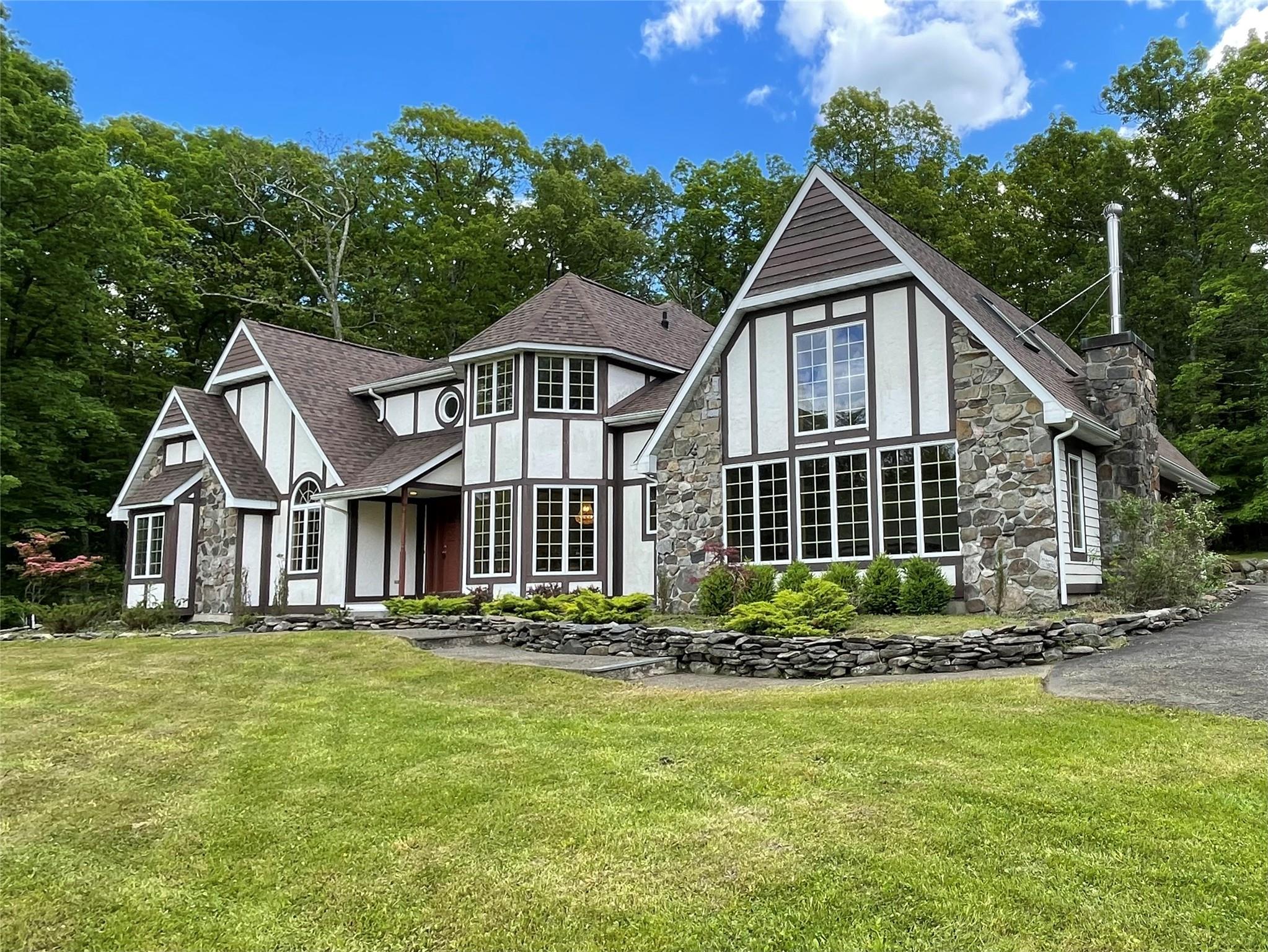 71 Saddleback Ridge Wallkill, NY 12589 - Photo 25 of 39 Rear view of house featuring stone siding, a yard, a shingled roof, and stucco siding