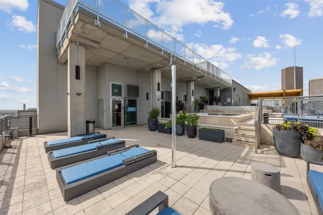 a building outdoor space with patio furniture and potted plants