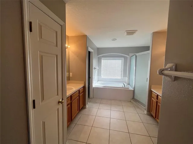 a spacious bathroom with a granite countertop sink mirror and bathtub